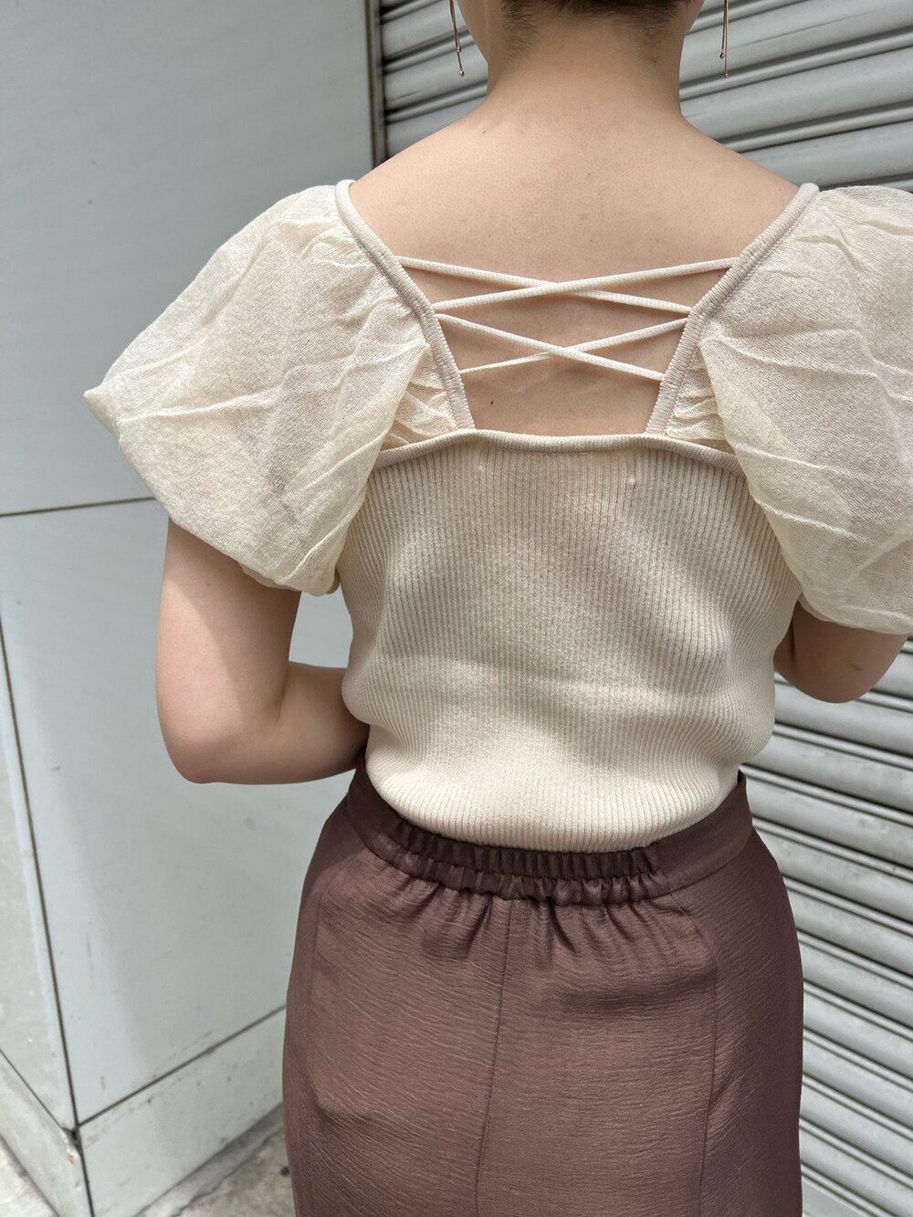 ベージュ系のサンダル、ブラウン系のスカート、ホワイト系のハンドバッグを着用したレディースの夏コーディネートの4枚目の写真