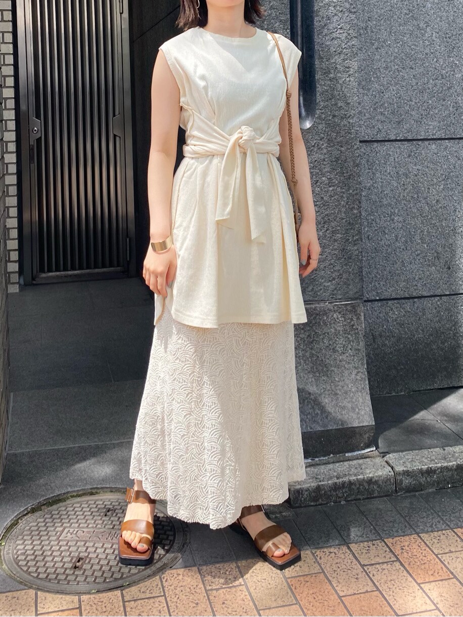 ベージュ系のショルダーバッグ、ホワイト系のスカート、ブラウン系のサンダルを着用したレディースの夏コーディネートの2枚目の写真