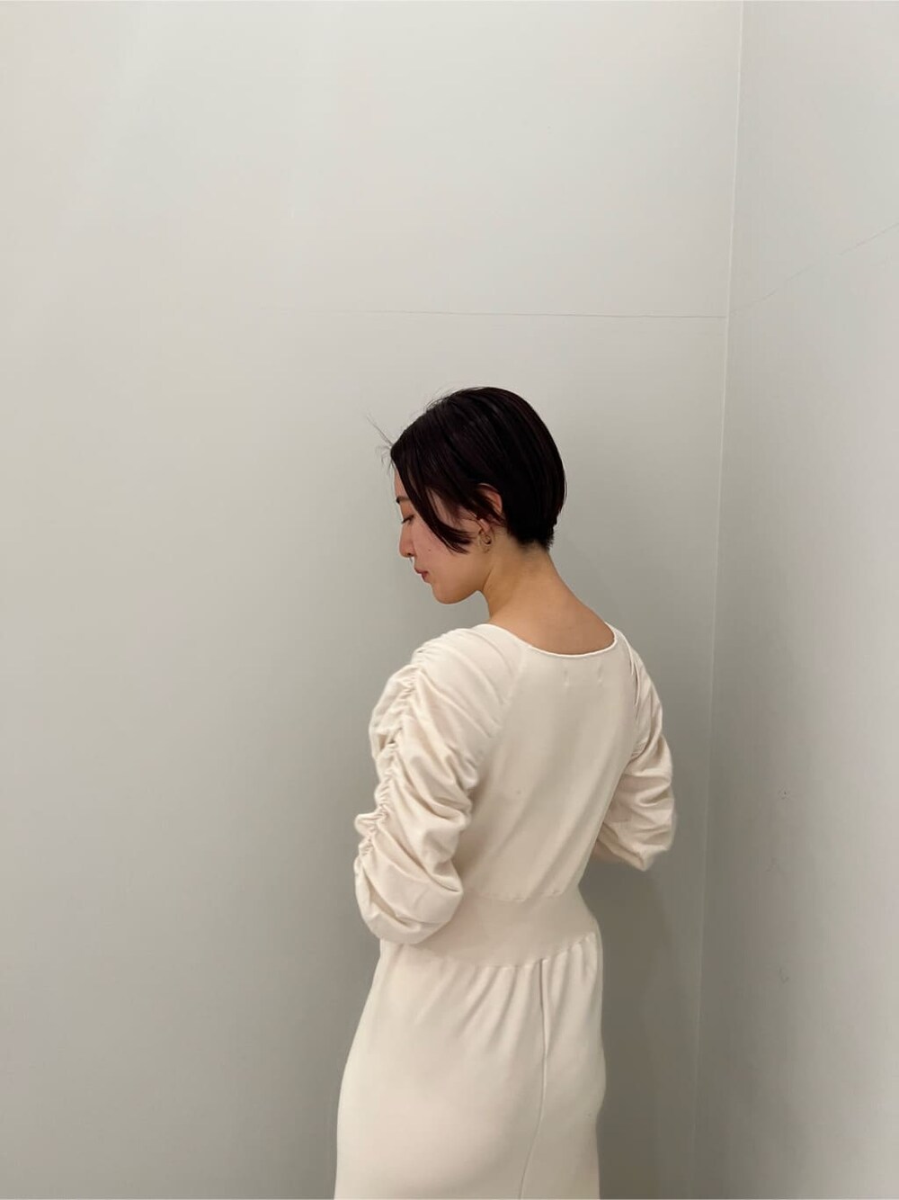 ベージュ系のブーツ、ホワイト系のワンピースを着用したレディースの冬コーディネートの3枚目の写真