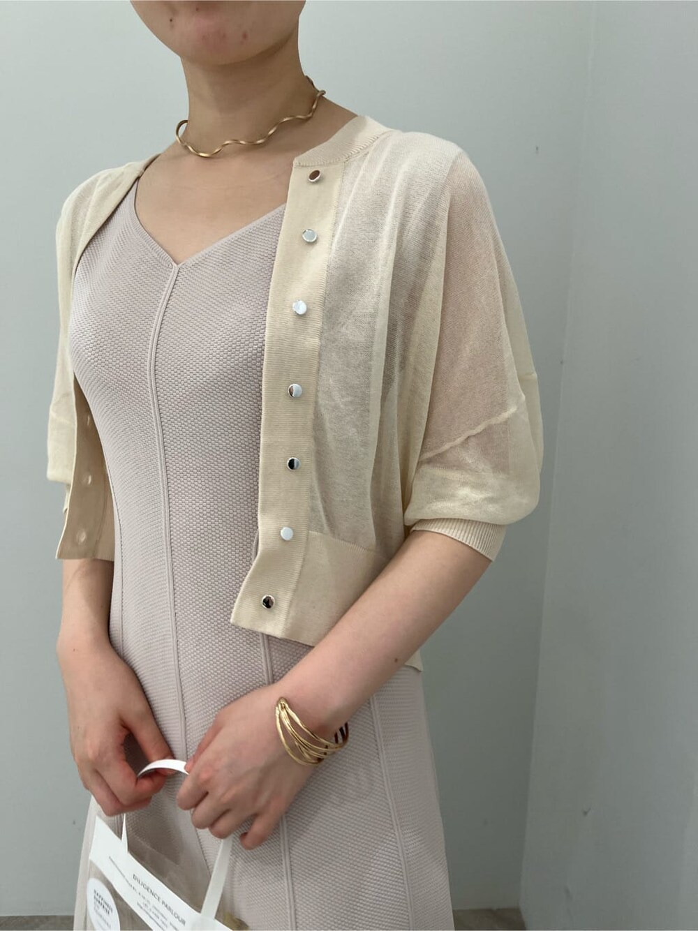 グリーン系のサンダル、ベージュ系のワンピース、ホワイト系のカーディガン/ボレロを着用したレディースの夏コーディネートの5枚目の写真