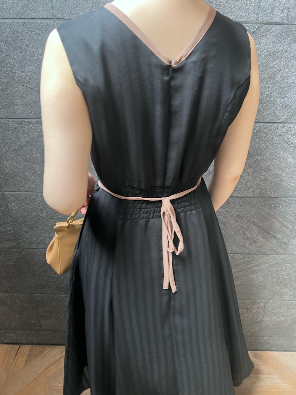 ブラック系のワンピース、ホワイト系のサンダル、レッド系のハンドバッグを着用したレディースの夏コーディネートの5枚目の写真