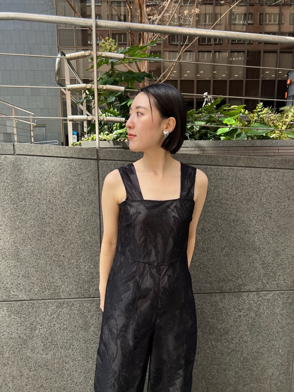 イエロー系のサンダル、ホワイト系のテーラードジャケット、ブラック系のつなぎ/オールインワンを着用したレディースの春コーディネートの7枚目の写真