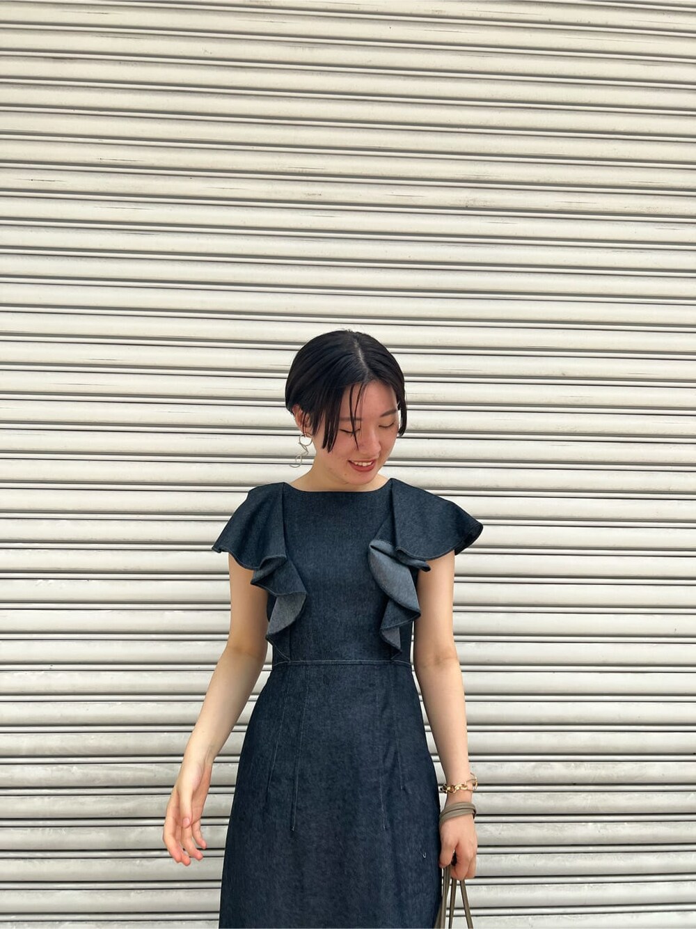 ベージュ系のハンドバッグ、レッド系のサンダル、ブラック系のワンピースを着用したレディースの夏コーディネートの4枚目の写真