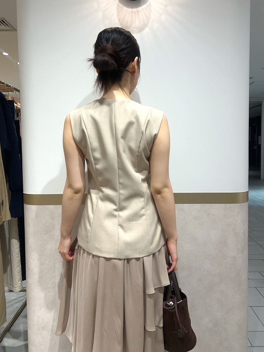 ベージュ系のワンピース、ブラック系のパンプス、ブラウン系のハンドバッグを着用したレディースの春コーディネートの6枚目の写真