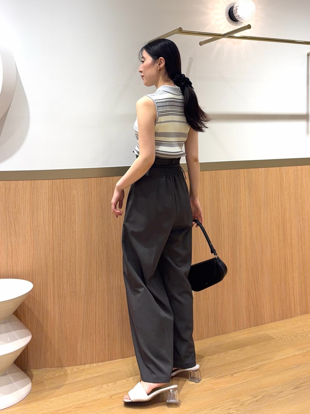グレー系のニット/セーター、グレー系のその他パンツ、ブラック系のハンドバッグを着用したレディースの春コーディネートの2枚目の写真