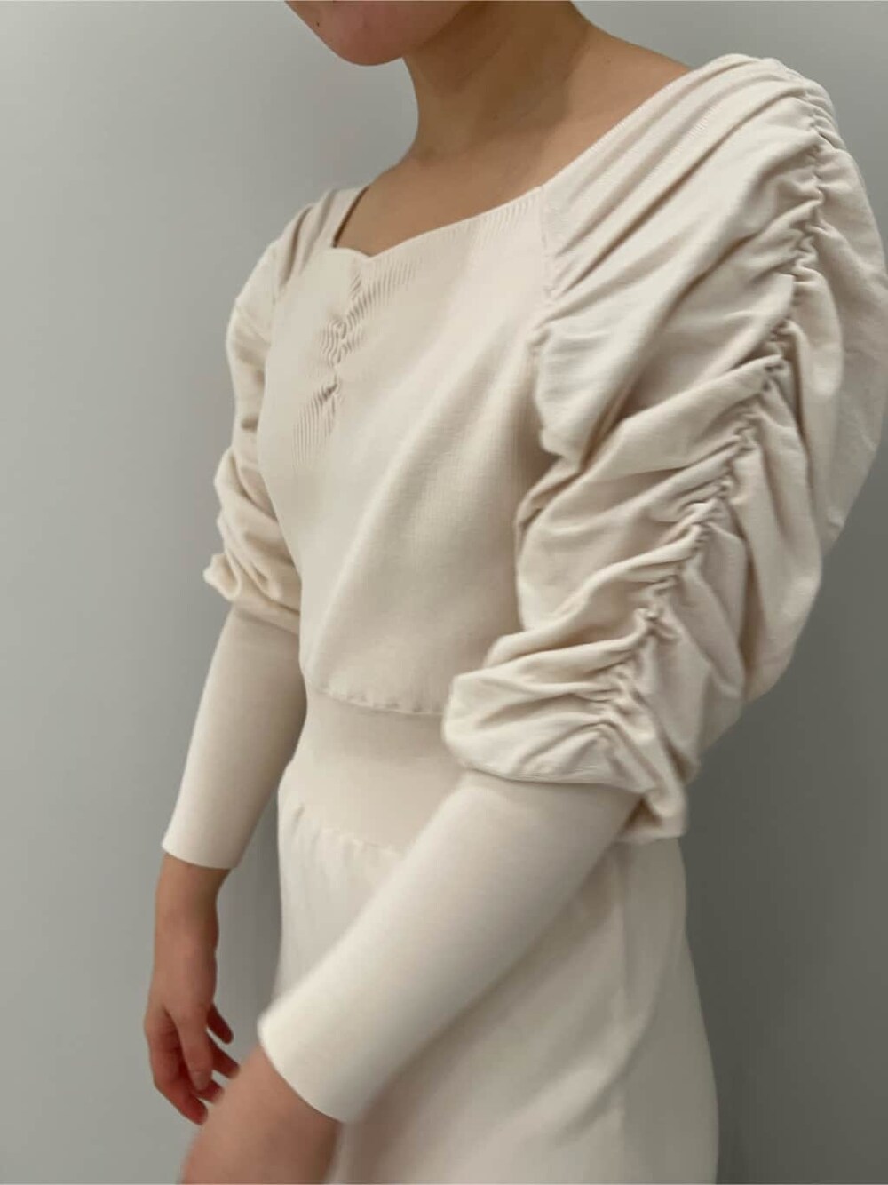 ベージュ系のブーツ、ホワイト系のワンピースを着用したレディースの冬コーディネートの6枚目の写真