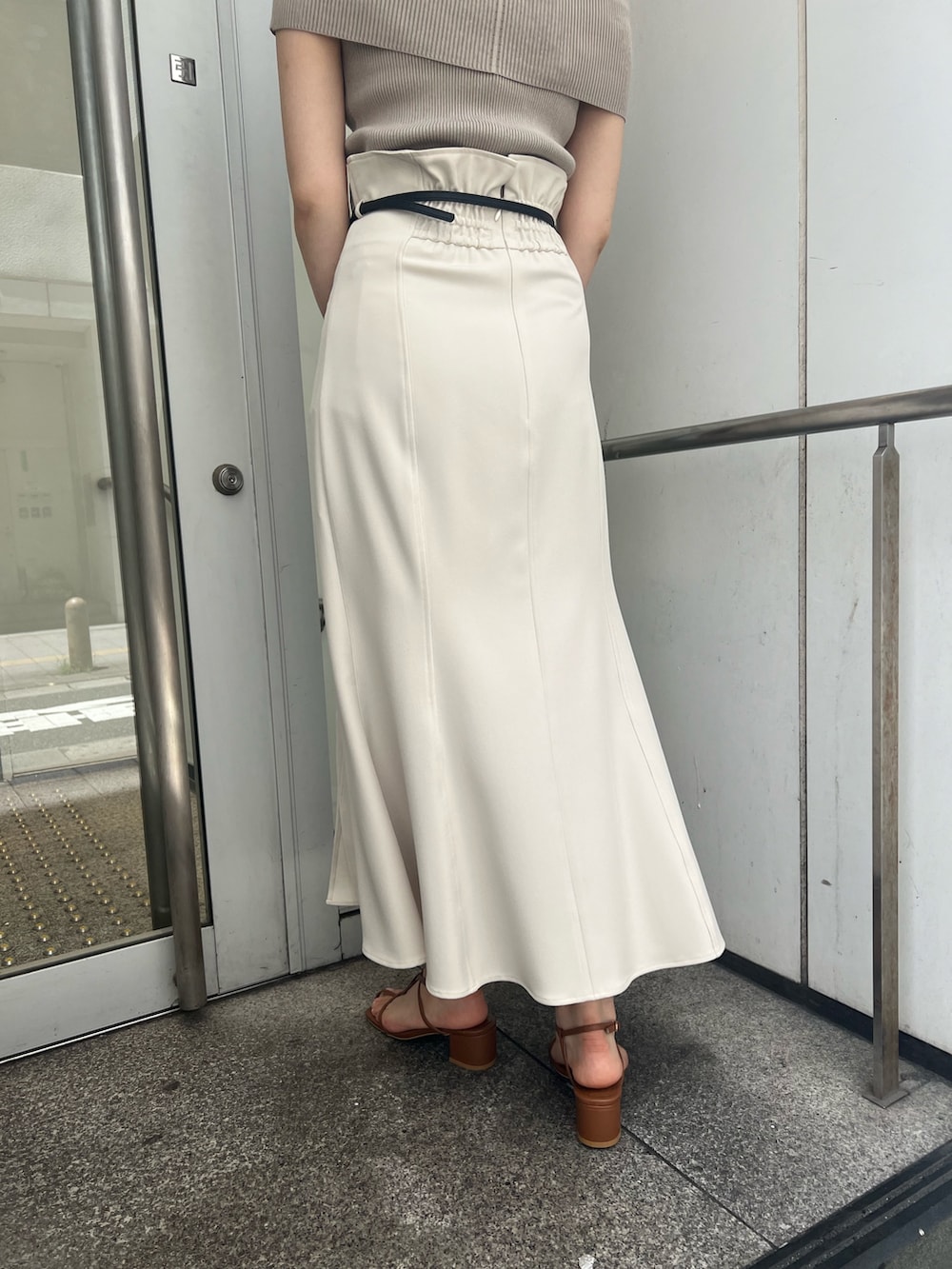 ホワイト系のショルダーバッグ、ホワイト系のスカート、ベージュ系のニット/セーターを着用したレディースの夏コーディネートの8枚目の写真