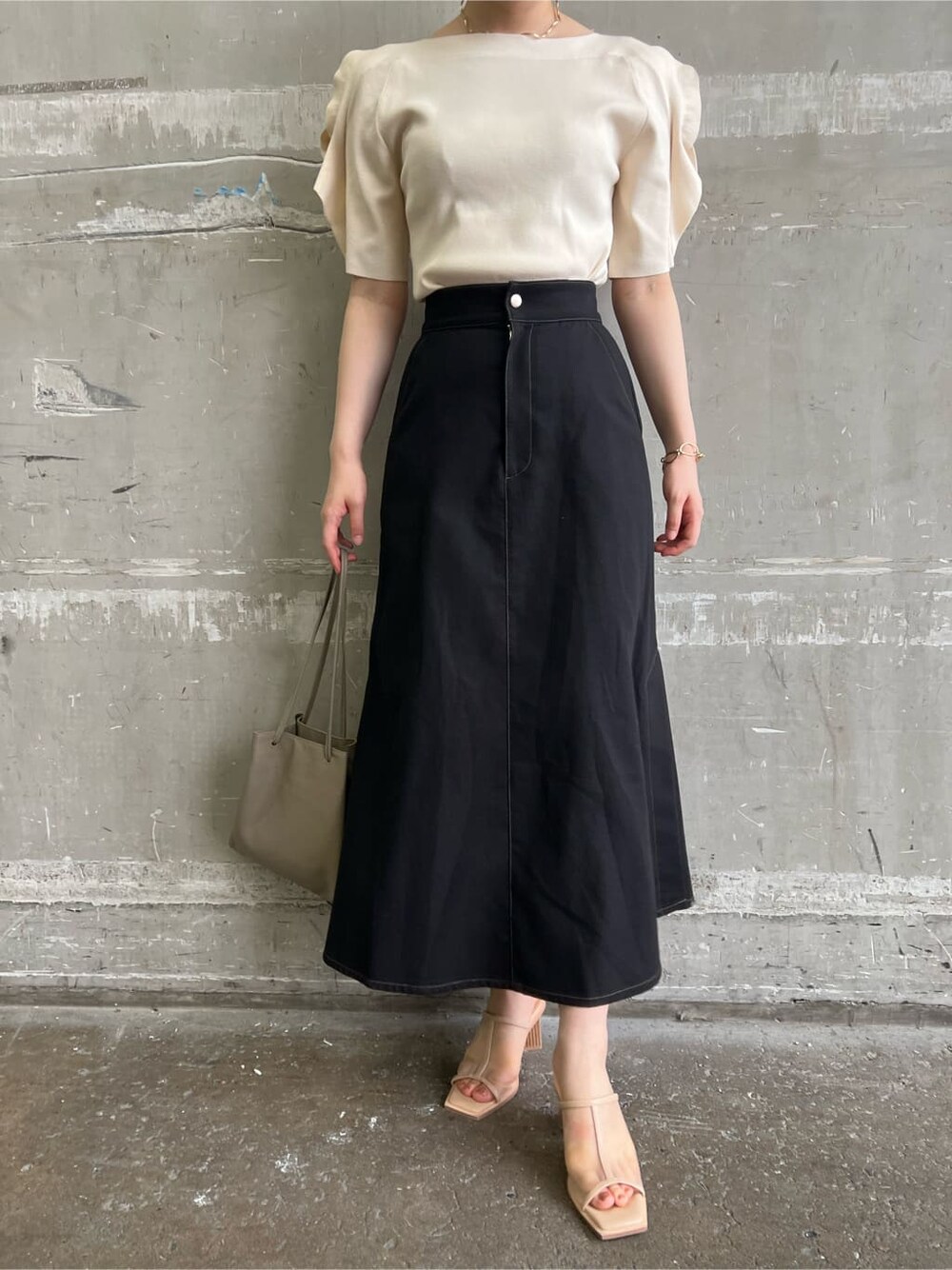 ベージュ系のハンドバッグ、ブラック系のスカート、ホワイト系のニット/セーターを着用したレディースの夏コーディネートの8枚目の写真