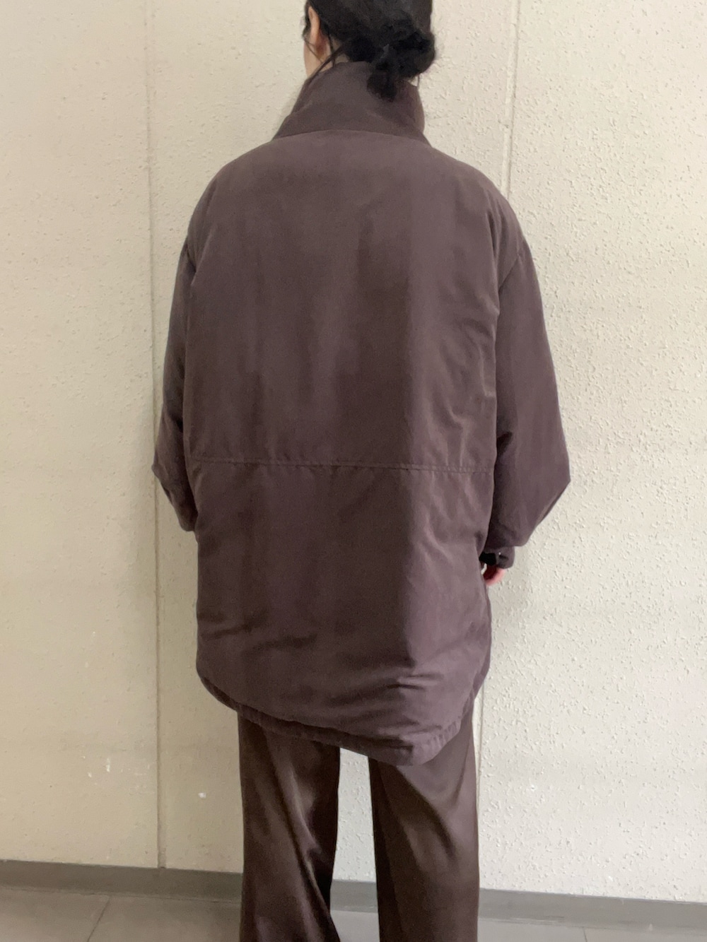 ベージュ系のニット/セーター、ブラウン系のダウンジャケット/コート、ブラウン系のその他パンツを着用したレディースの冬コーディネートの7枚目の写真