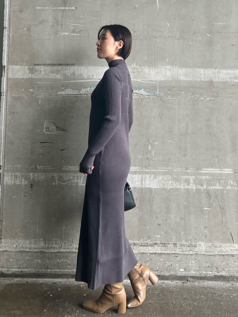 ブラック系のハンドバッグ、ベージュ系のブーツ、ホワイト系のカーディガン/ボレロを着用したレディースの冬コーディネートの4枚目の写真