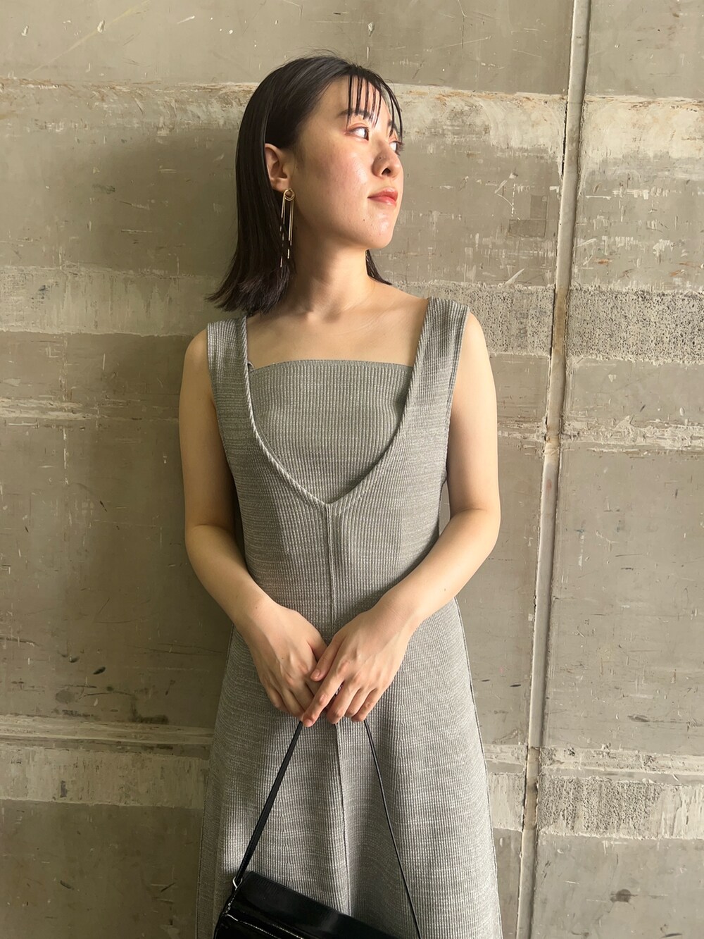 ブラック系のショルダーバッグ、ブラック系のサンダル、グリーン系のワンピースを着用したレディースの夏コーディネートの3枚目の写真