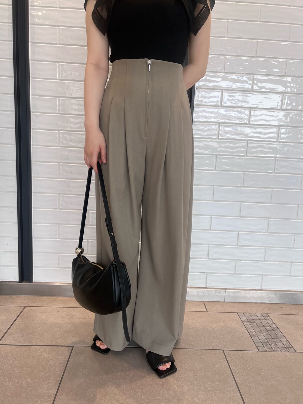 ブラウン系のその他パンツ、ブラック系のニット/セーター、ブラック系のサンダルを着用したレディースの春コーディネートの7枚目の写真