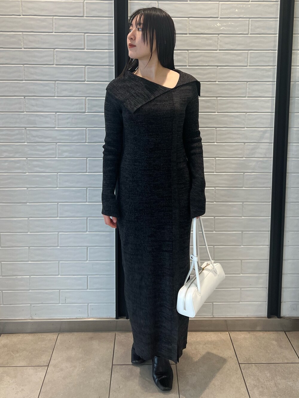 ホワイト系のダウンジャケット/コート、ブラック系のワンピース、ブラック系のブーツを着用したレディースの冬コーディネートの6枚目の写真