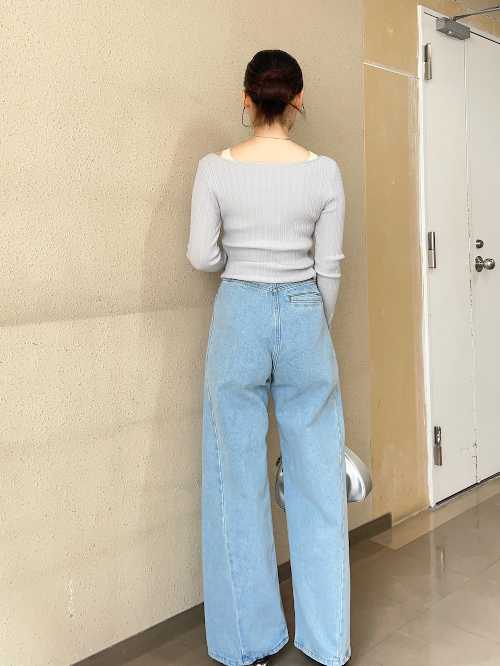 グレー系のニット/セーター、ブルー系のデニムパンツ、ブラック系のパンプスを着用したレディースの春コーディネートの3枚目の写真