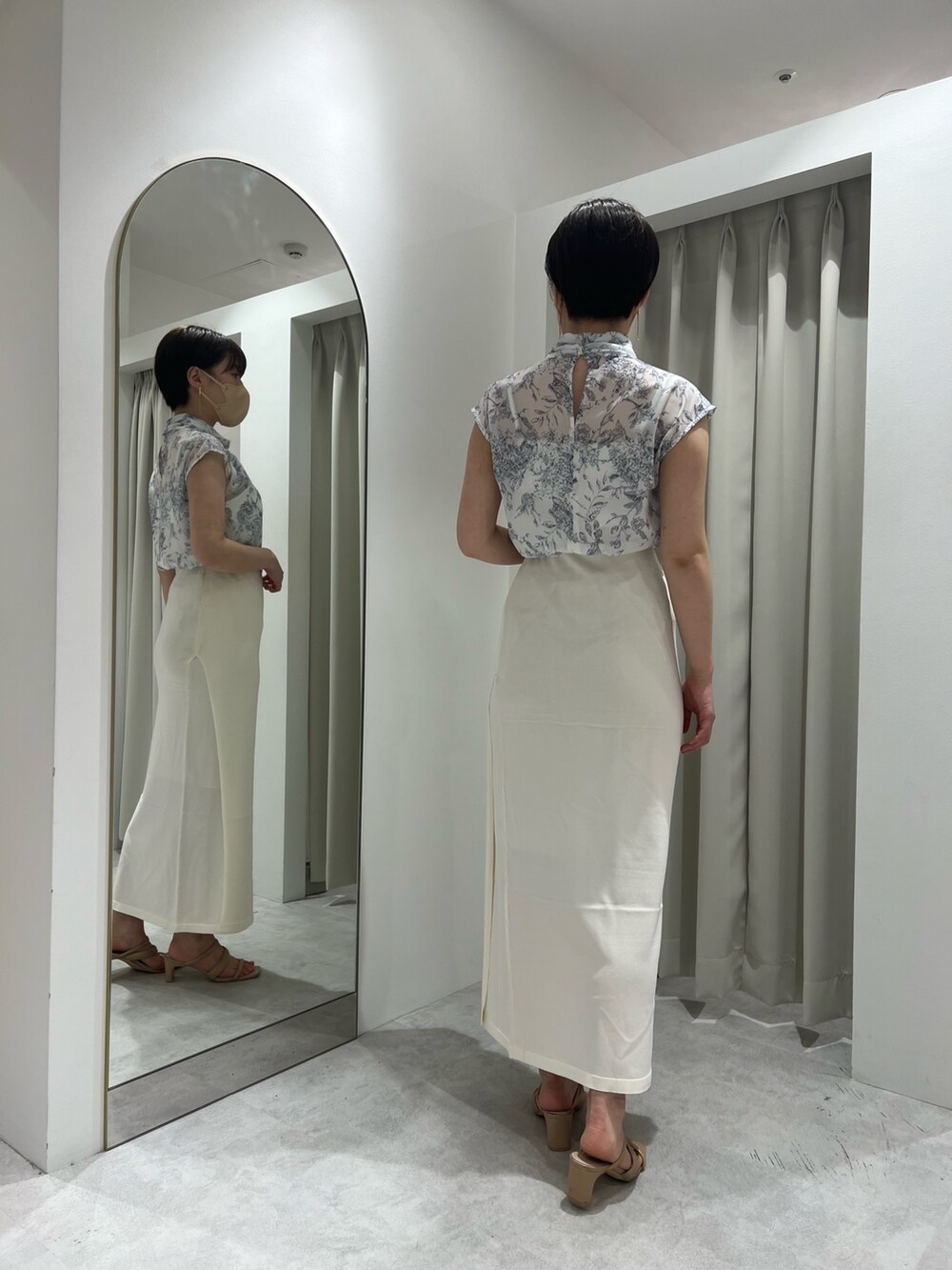 ホワイト系のスカート、ベージュ系のサンダル、ブルー系のシャツ/ブラウスを着用したレディースの春コーディネートの2枚目の写真