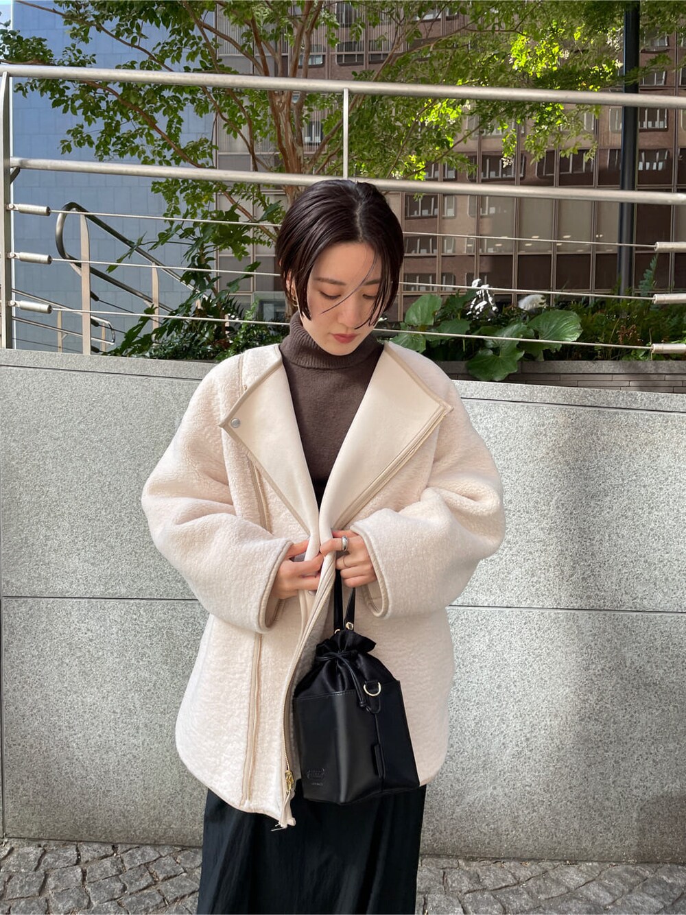 ベージュ系のその他シューズ、ホワイト系のその他アウター、ブラック系のスカートを着用したレディースの秋コーディネートの9枚目の写真