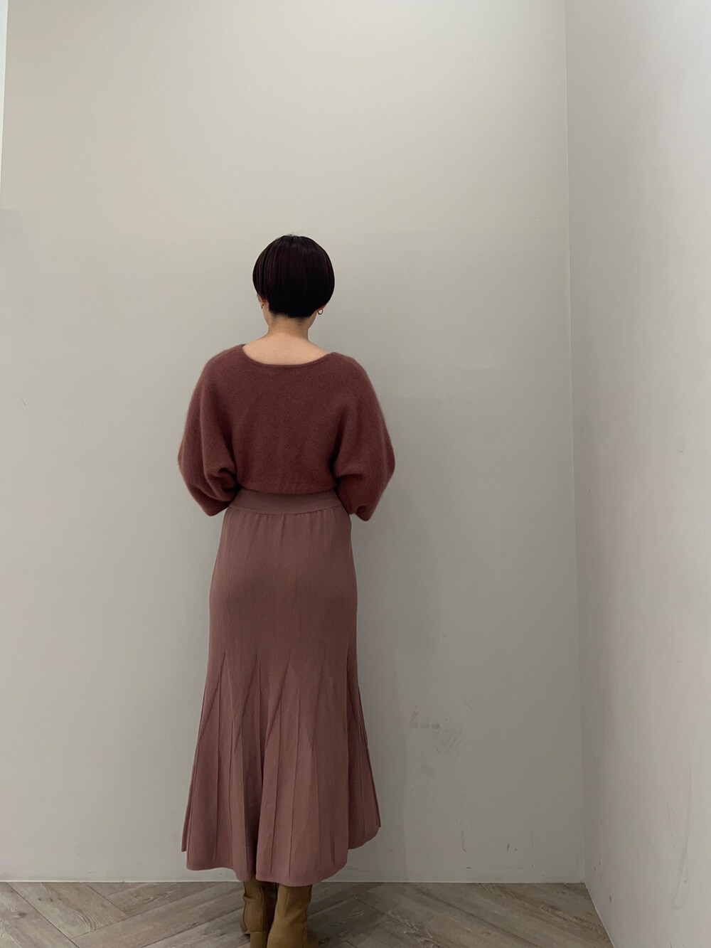 ピンク系のカーディガン/ボレロ、ピンク系のワンピース、ベージュ系のブーツを着用したレディースの秋コーディネートの5枚目の写真