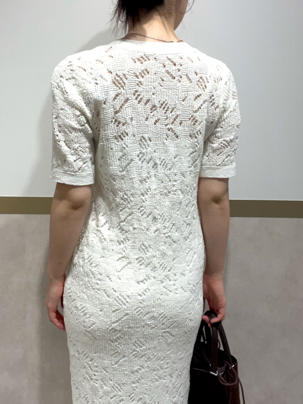 ホワイト系のワンピース、グリーン系のパンプス、ブラウン系のハンドバッグを着用したレディースの春コーディネートの6枚目の写真