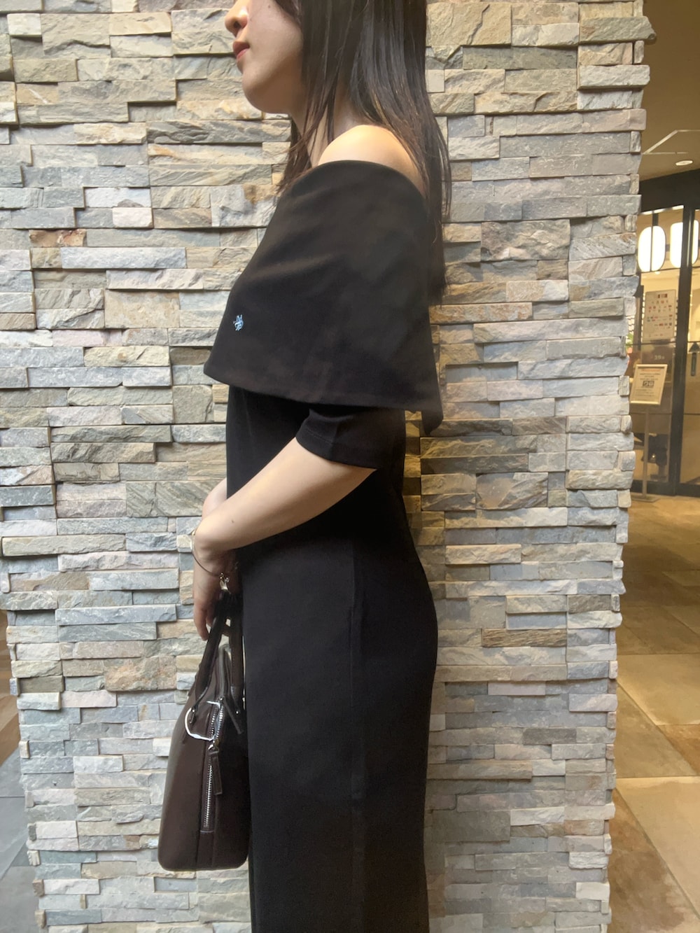 ブラウン系のボストンバッグ、ブラック系のワンピース、ブラウン系のパンプスを着用したレディースの夏コーディネートの5枚目の写真