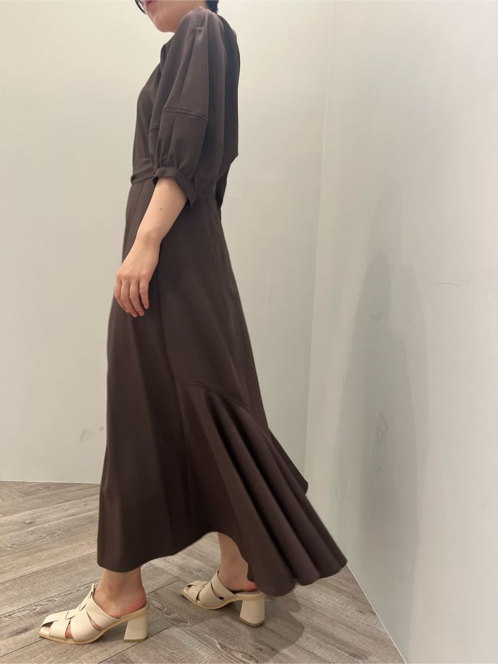 ホワイト系のサンダル、ブラウン系のワンピース、ホワイト系のショルダーバッグを着用したレディースの夏コーディネートの2枚目の写真