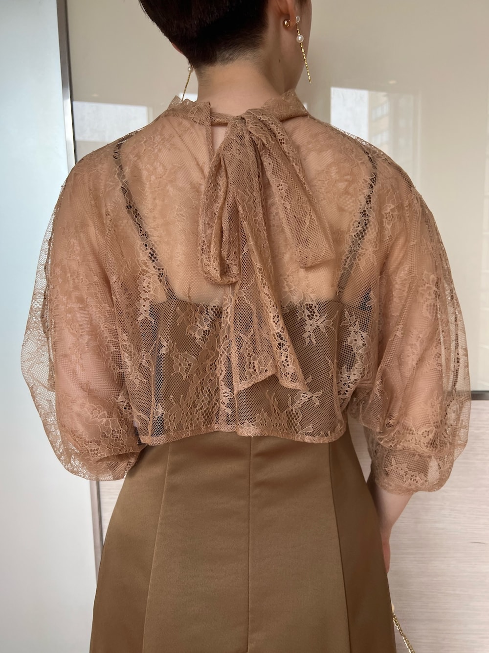 ベージュ系のクラッチバッグ、ブラウン系のドレス、ベージュ系のパンプスを着用したレディースの夏コーディネートの6枚目の写真