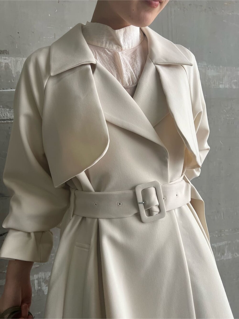 ホワイト系のトレンチコート、ベージュ系のワンピース、ベージュ系のハンドバッグを着用したレディースの春コーディネートの5枚目の写真