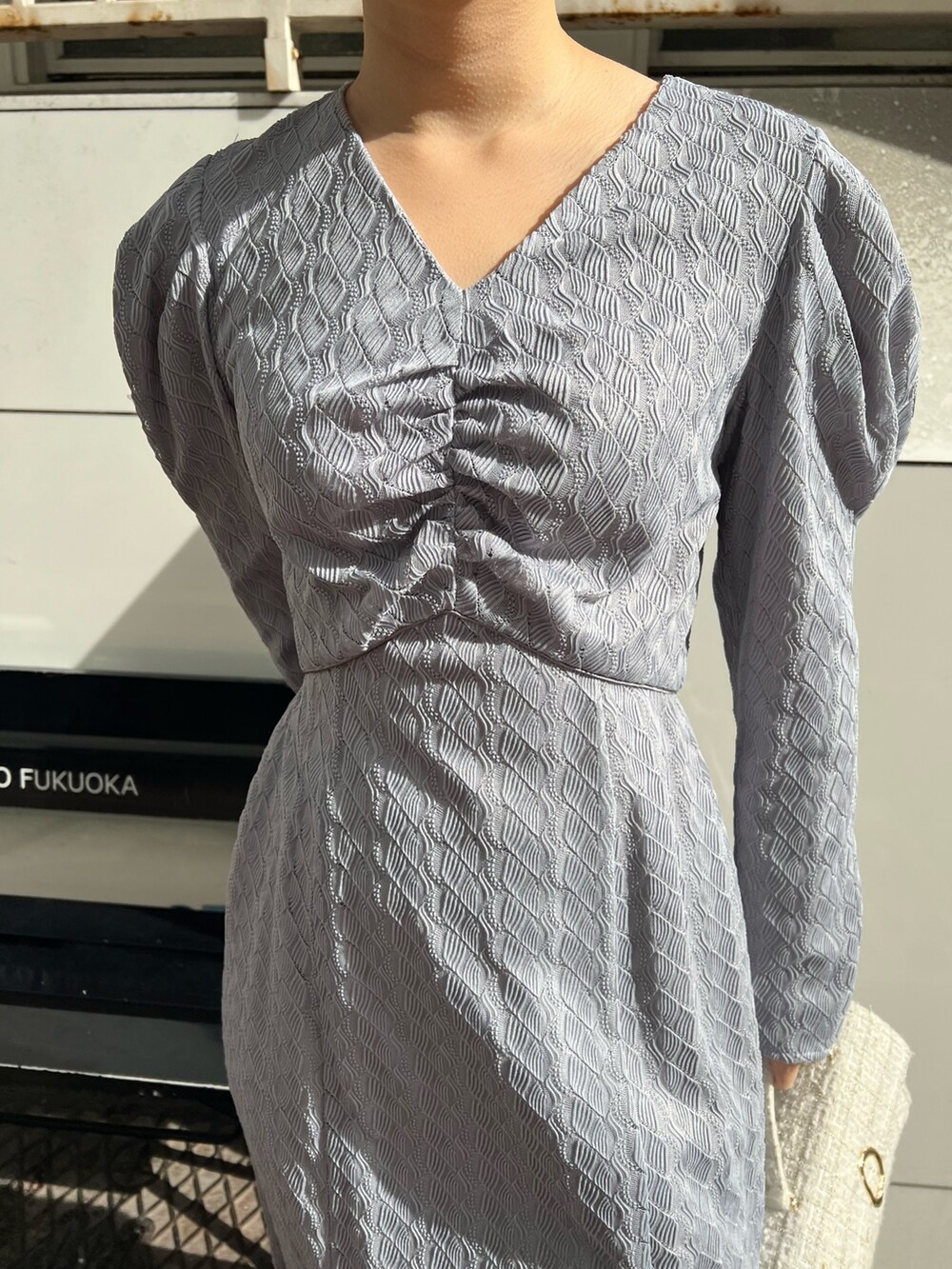 ホワイト系のショルダーバッグ、ベージュ系のブーツ、ベージュ系のその他アウターを着用したレディースの冬コーディネートの8枚目の写真