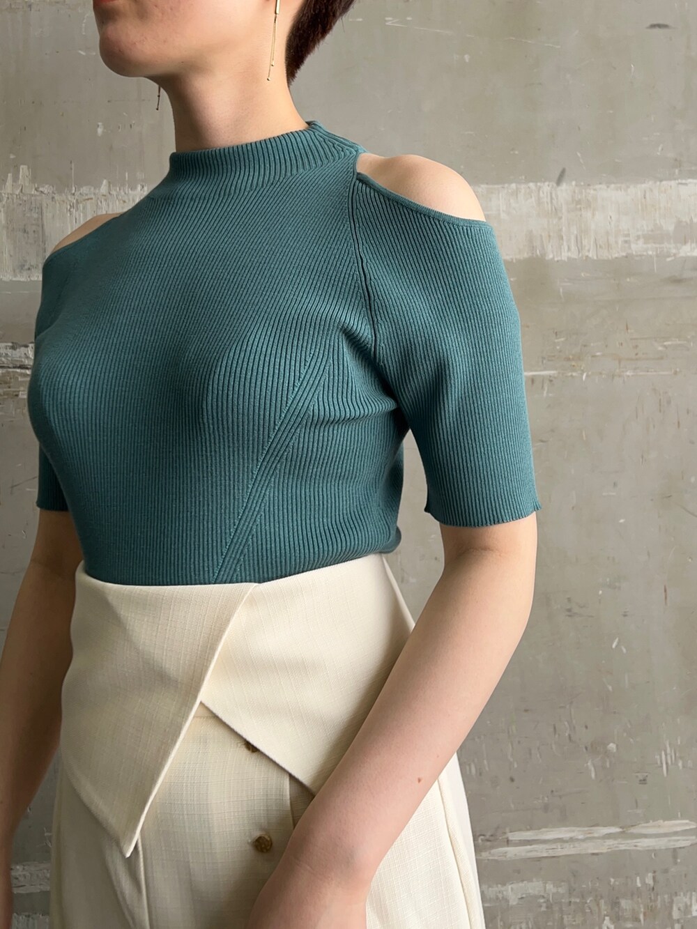 ホワイト系のハンドバッグ、グリーン系のニット/セーター、ホワイト系のスカートを着用したレディースの夏コーディネートの4枚目の写真