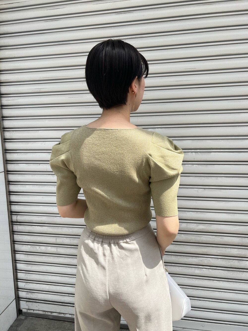 ホワイト系のハンドバッグ、ベージュ系のサンダル、ベージュ系のその他パンツを着用したレディースの春コーディネートの6枚目の写真