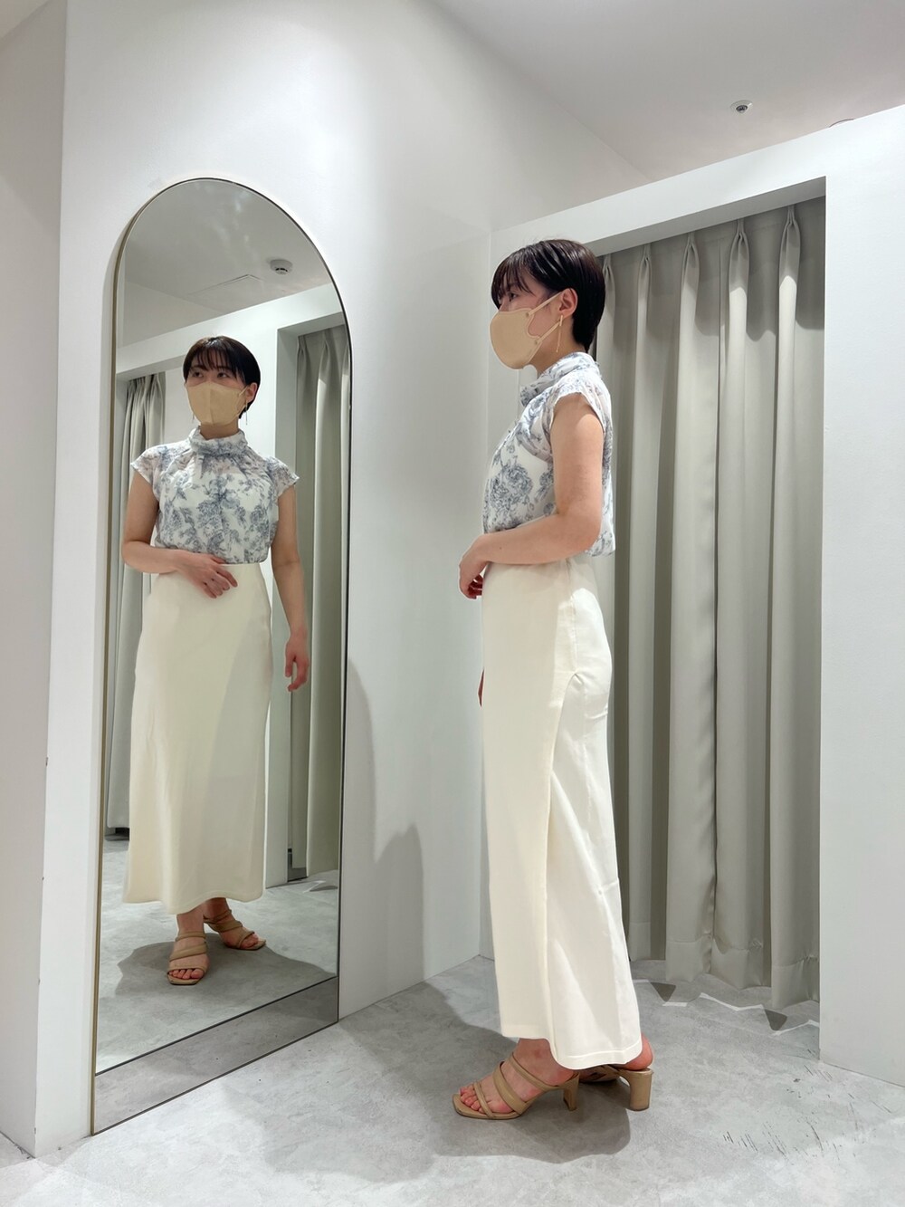 ホワイト系のスカート、ベージュ系のサンダル、ブルー系のシャツ/ブラウスを着用したレディースの春コーディネートの3枚目の写真