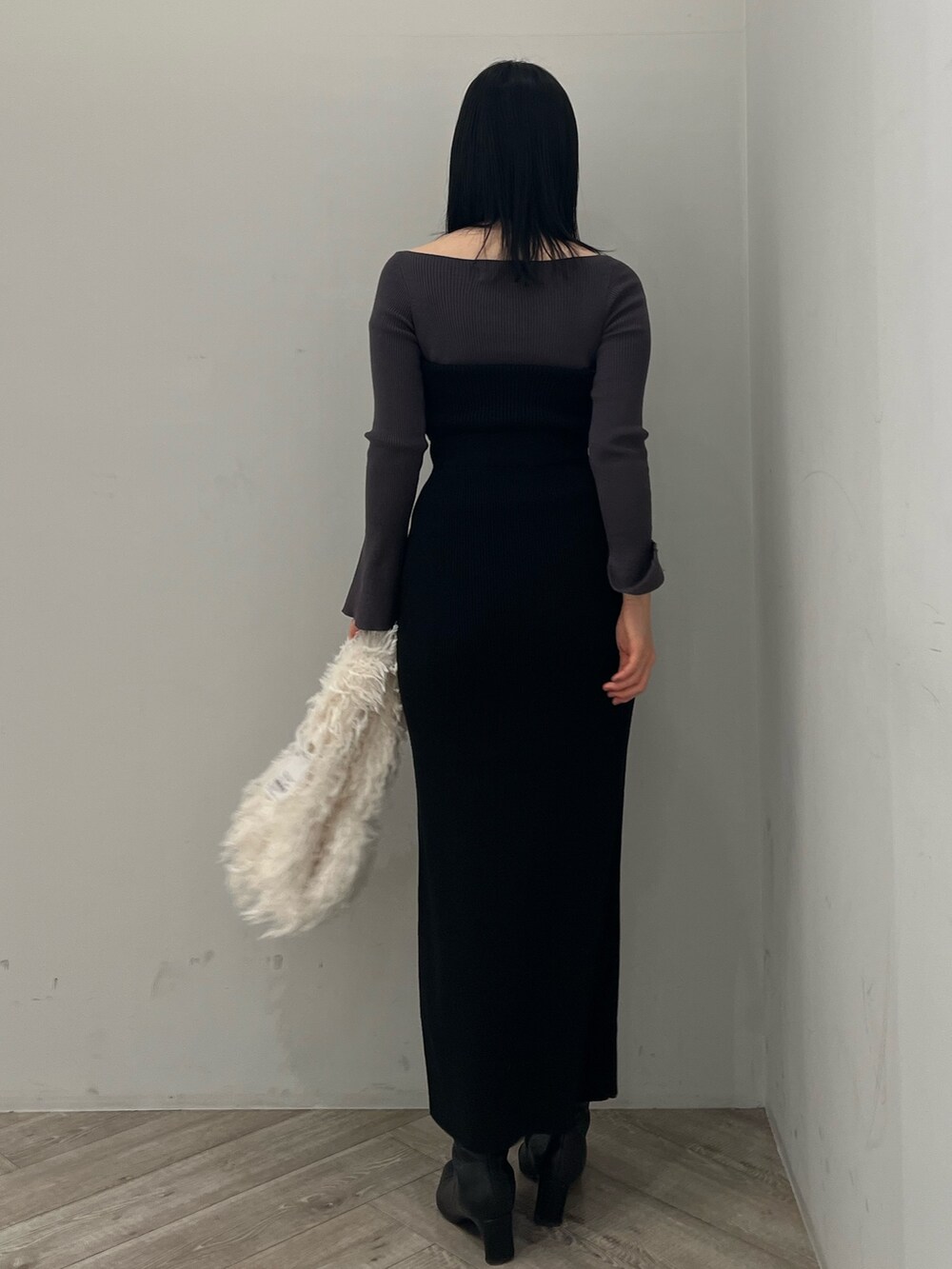 グレー系のニット/セーター、ブラック系のワンピースを着用したレディースの冬コーディネートの3枚目の写真