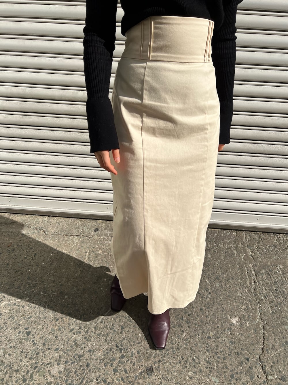 レッド系のブーツ、ホワイト系のスカート、ホワイト系のカーディガン/ボレロを着用したレディースの冬コーディネートの7枚目の写真