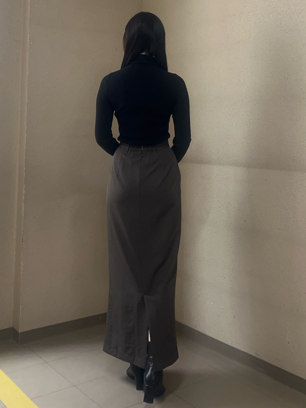 ブラック系のブーツ、ブラック系のニット/セーター、ブラウン系のスカートを着用したレディースの秋コーディネートの3枚目の写真