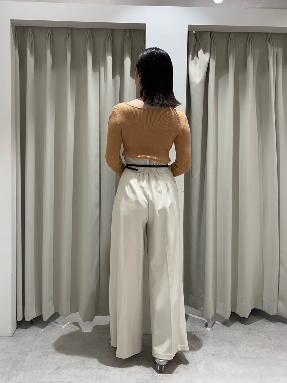 オレンジ系のニット/セーター、シルバー系のパンプス、ホワイト系のその他パンツを着用したレディースの秋コーディネートの3枚目の写真