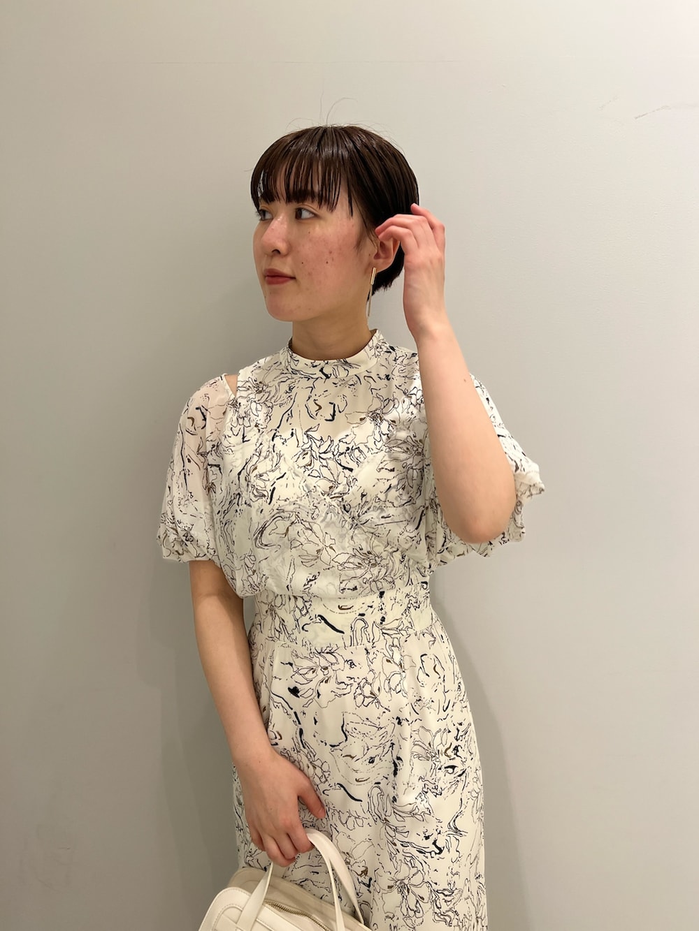 ブラウン系のサンダル、ホワイト系のショルダーバッグ、ホワイト系のワンピースを着用したレディースの春コーディネートの3枚目の写真