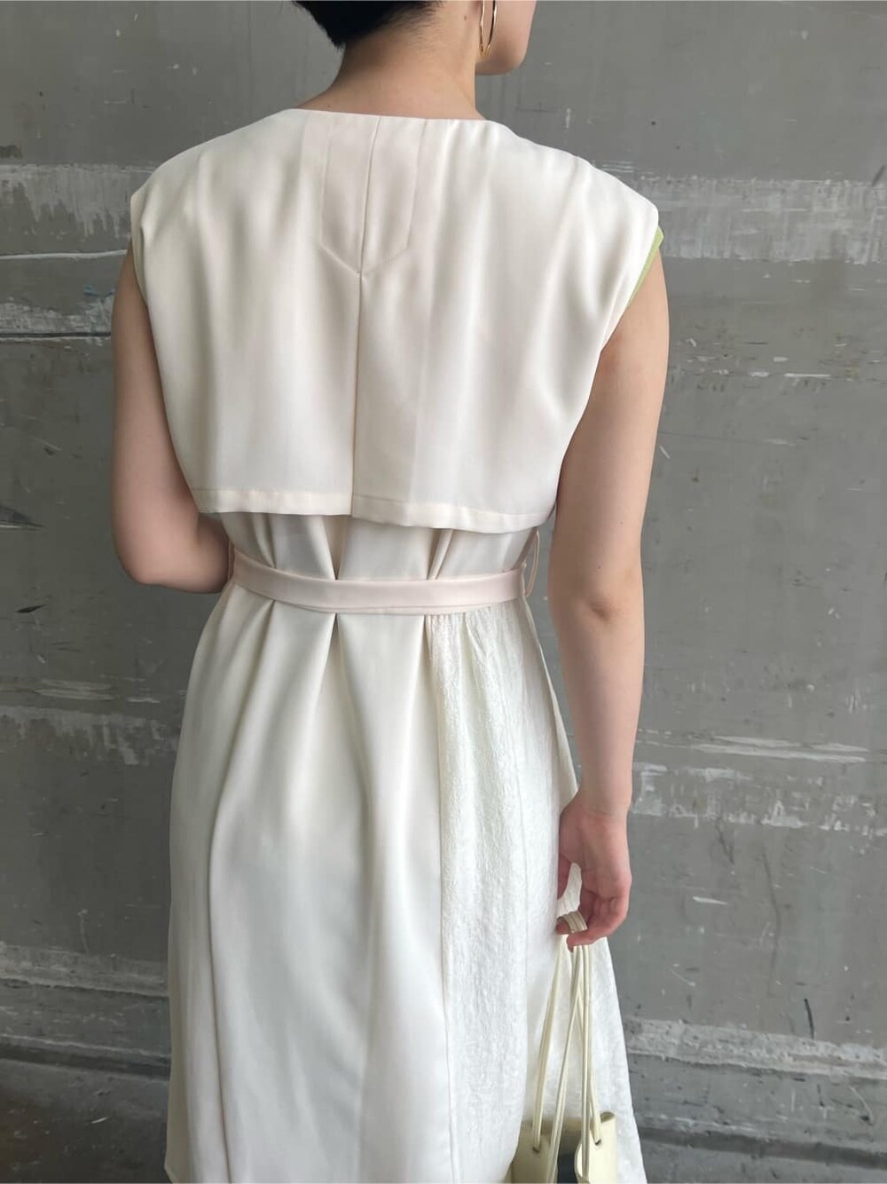 ホワイト系のハンドバッグ、ホワイト系のワンピース、グリーン系のサンダルを着用したレディースの春コーディネートの7枚目の写真