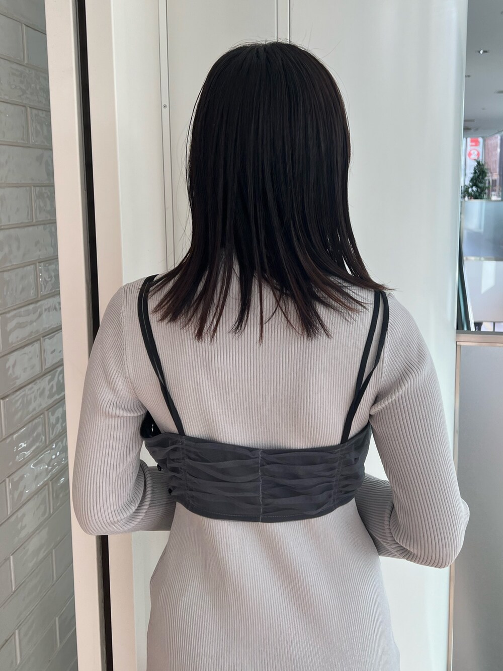 ブラック系のステンカラーコート、ブルー系のワンピース、ブラック系のブーツを着用したレディースの冬コーディネートの8枚目の写真