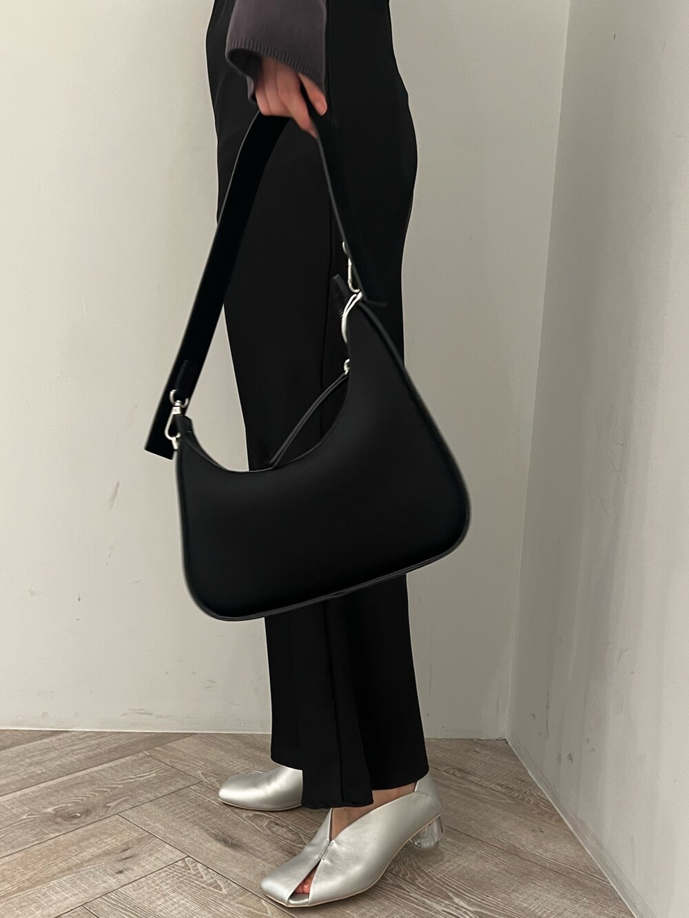 ブラック系のハンドバッグ、シルバー系のパンプス、ブラック系のワンピースを着用したレディースの冬コーディネートの6枚目の写真