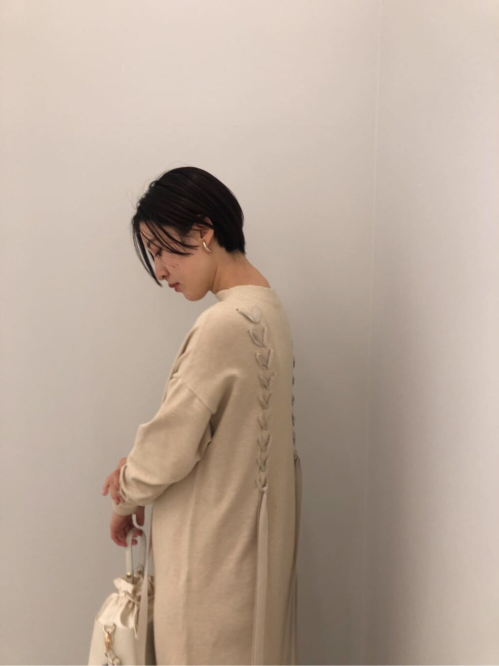 ホワイト系のワンピース、ホワイト系のハンドバッグ、ベージュ系のその他シューズを着用したレディースの秋コーディネートの3枚目の写真