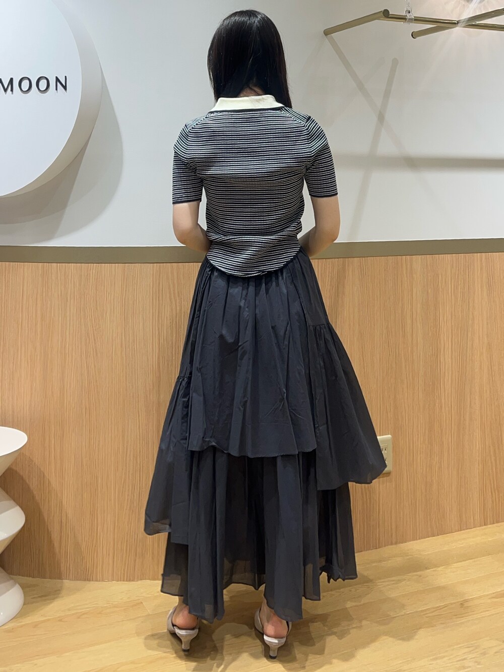 グレー系のスカート、その他のニット/セーター、ベージュ系のサンダルを着用したレディースの春コーディネートの3枚目の写真