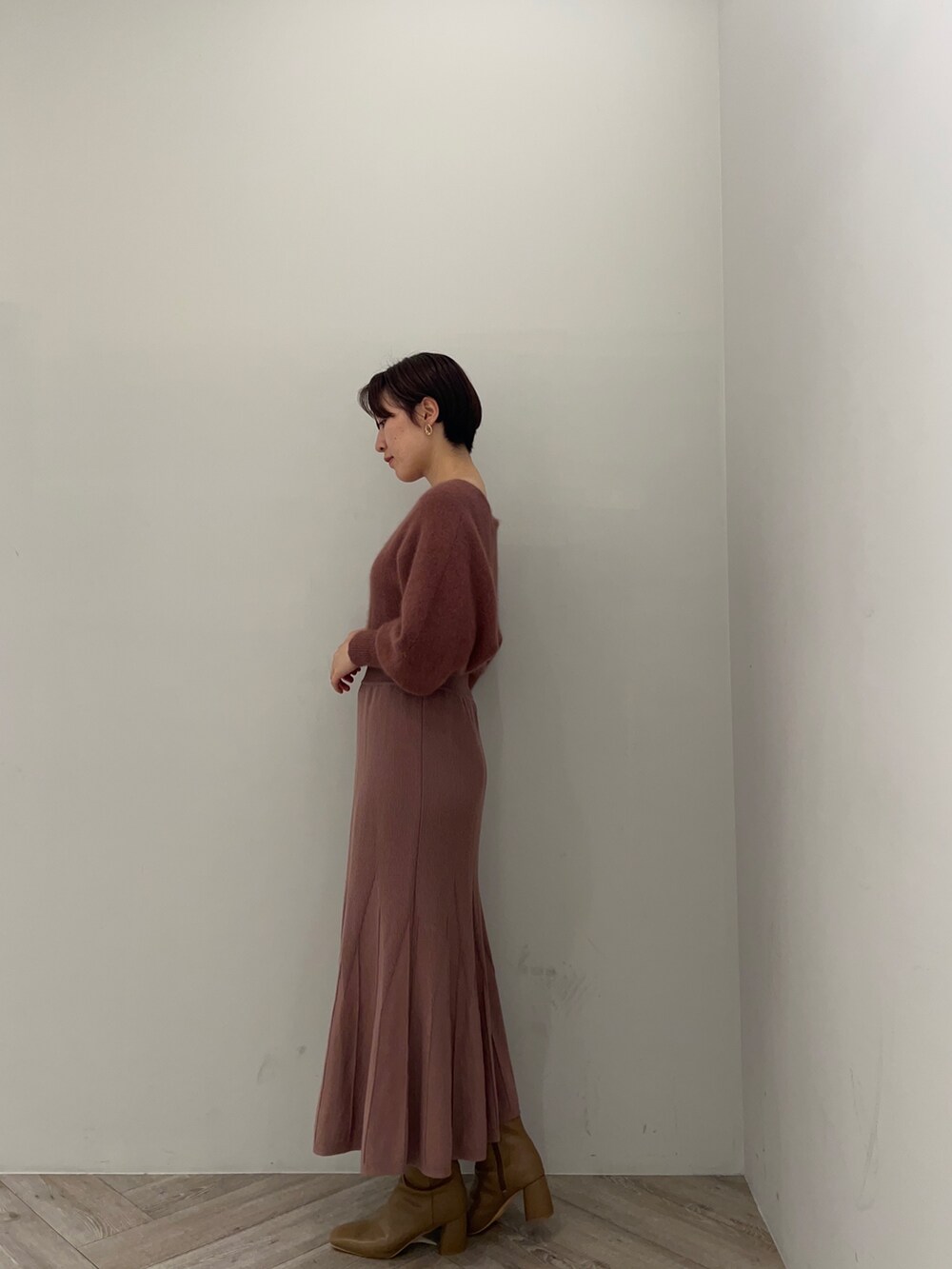 ピンク系のカーディガン/ボレロ、ピンク系のワンピース、ベージュ系のブーツを着用したレディースの秋コーディネートの4枚目の写真