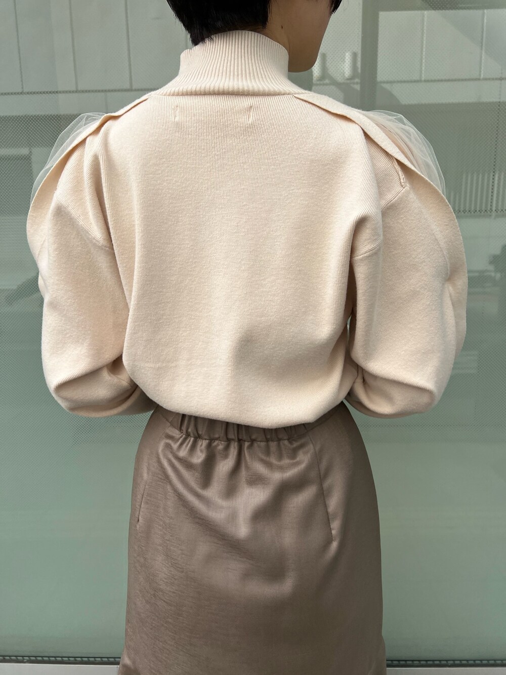 レッド系のブーツ、ベージュ系のスカート、ホワイト系のニット/セーターを着用したレディースの冬コーディネートの6枚目の写真