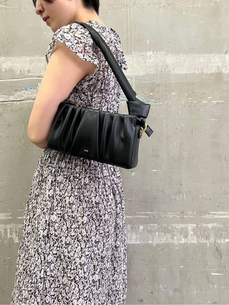 ブラウン系のパンプス、ブラック系のワンピース、ブラック系のハンドバッグを着用したレディースの夏コーディネートの4枚目の写真