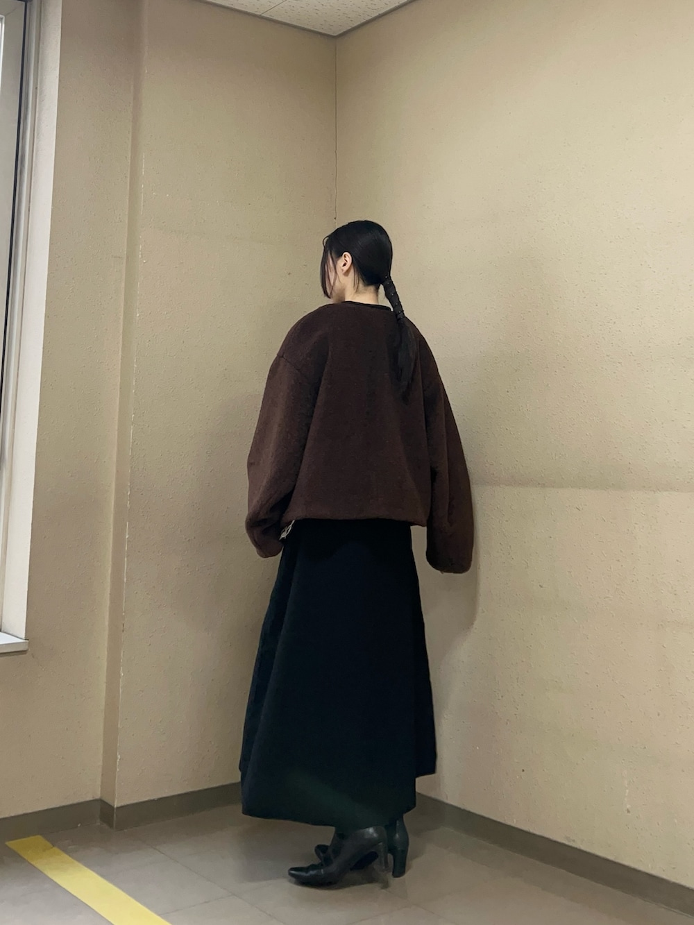 ブラック系のワンピース、ブラウン系のブルゾンを着用したレディースの冬コーディネートの2枚目の写真