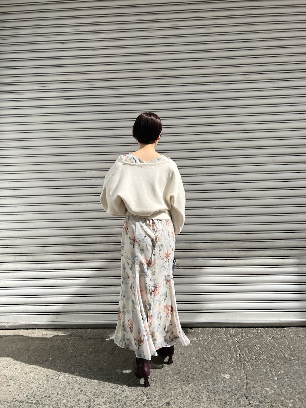 レッド系のブーツ、パープル系のハンドバッグ、ホワイト系のカーディガン/ボレロを着用したレディースの冬コーディネートの3枚目の写真