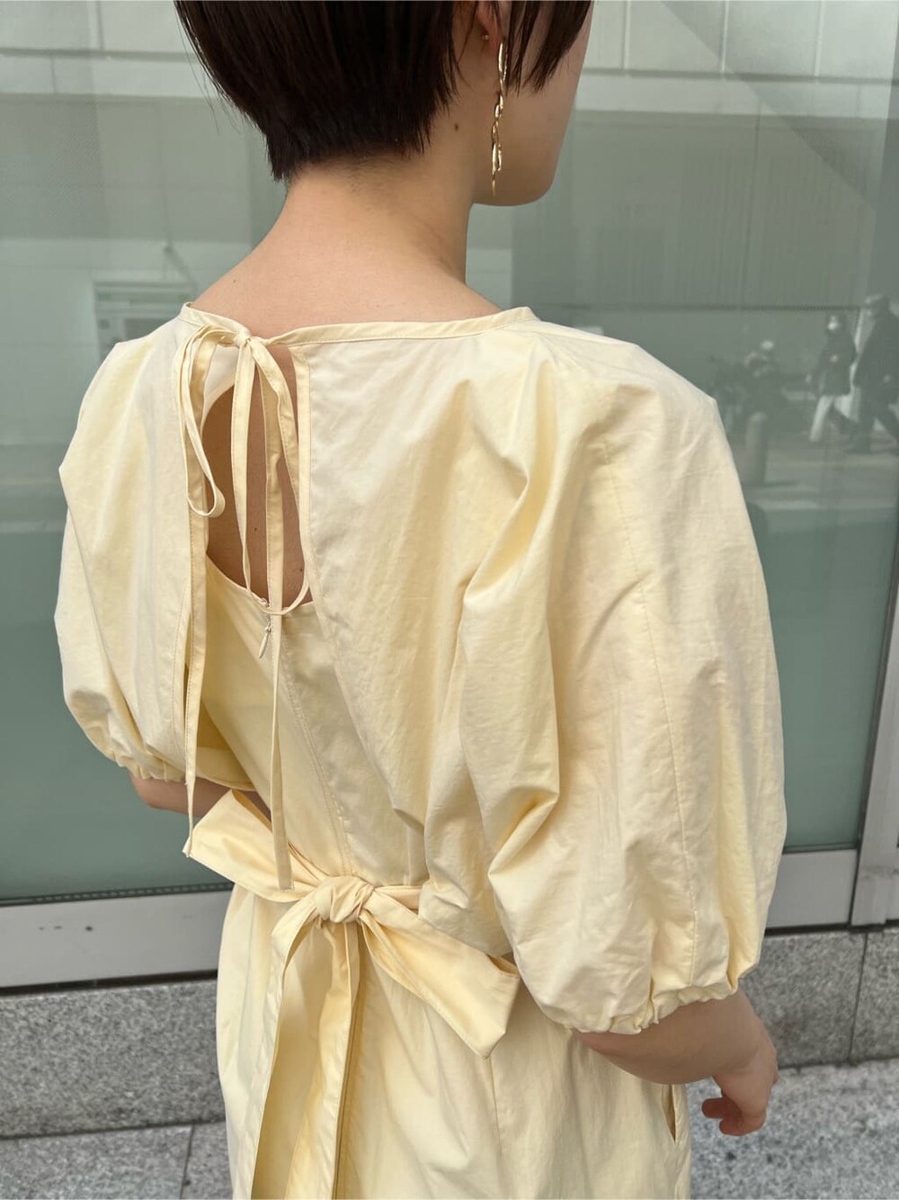 ブルー系のトレンチコート、ブラック系のワンピース、ブラウン系のパンプスを着用したレディースの春コーディネートの8枚目の写真