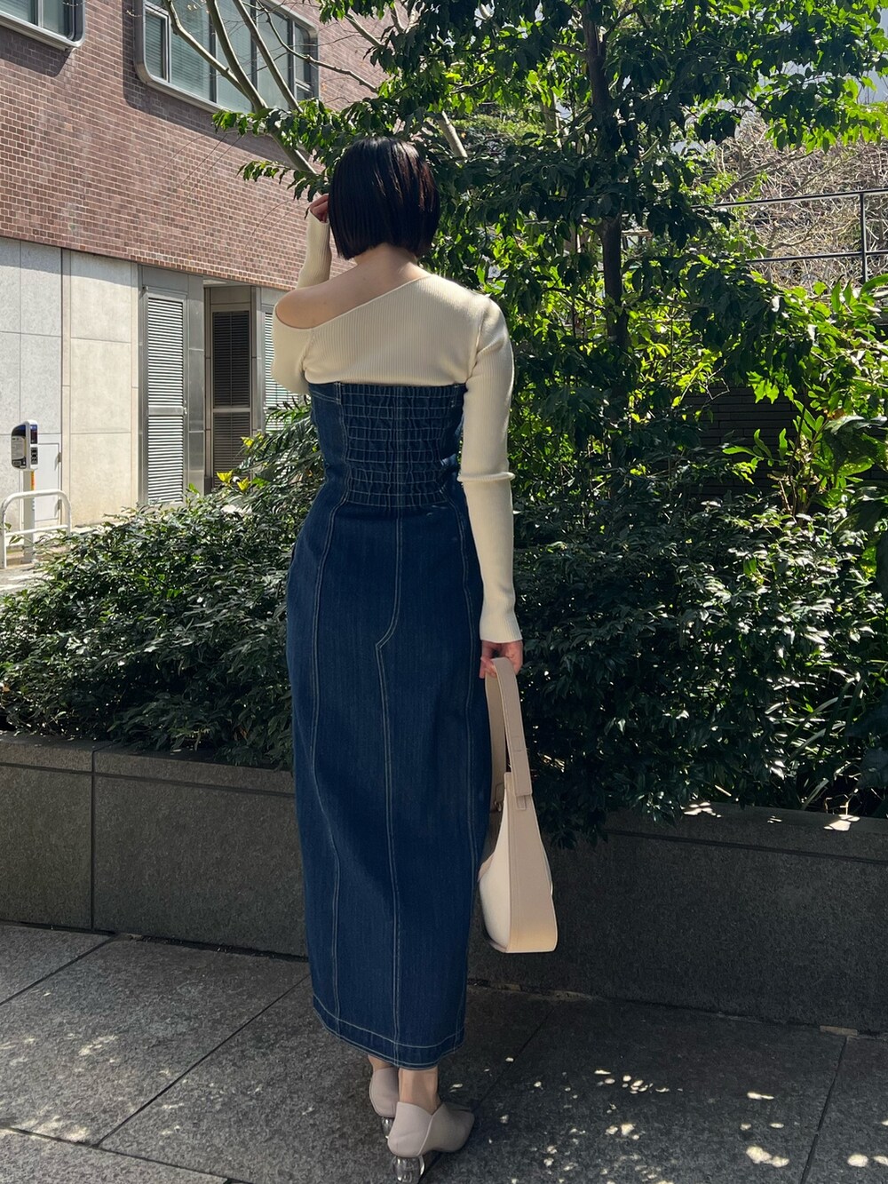 ホワイト系のパンプス、ブルー系のワンピース、ホワイト系のニット/セーターを着用したレディースの春コーディネートの2枚目の写真