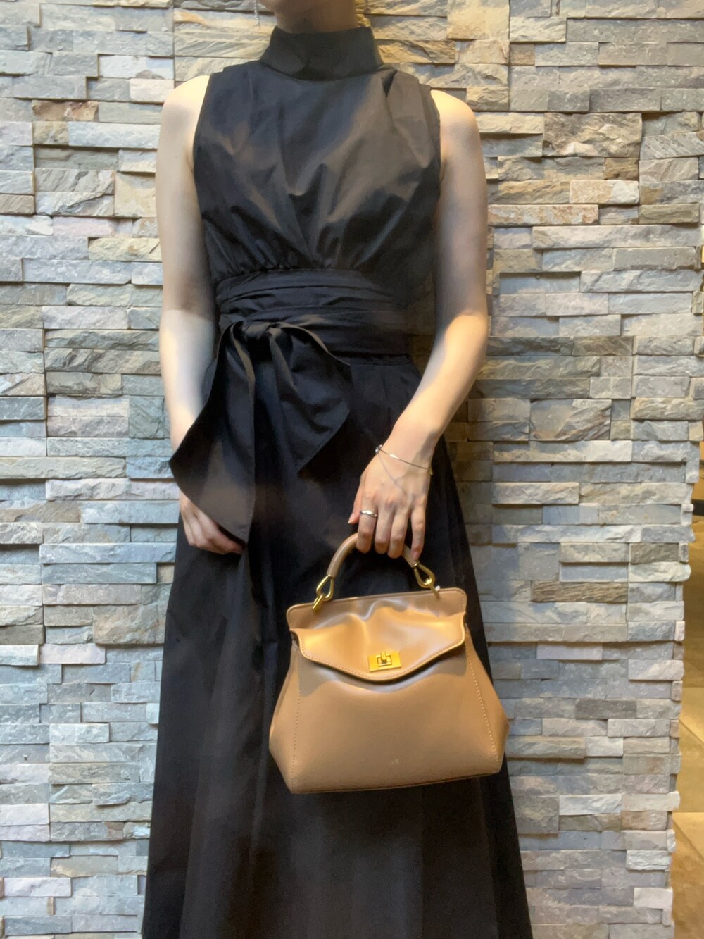 ブラック系のワンピース、ホワイト系のサンダル、レッド系のハンドバッグを着用したレディースの夏コーディネートの4枚目の写真