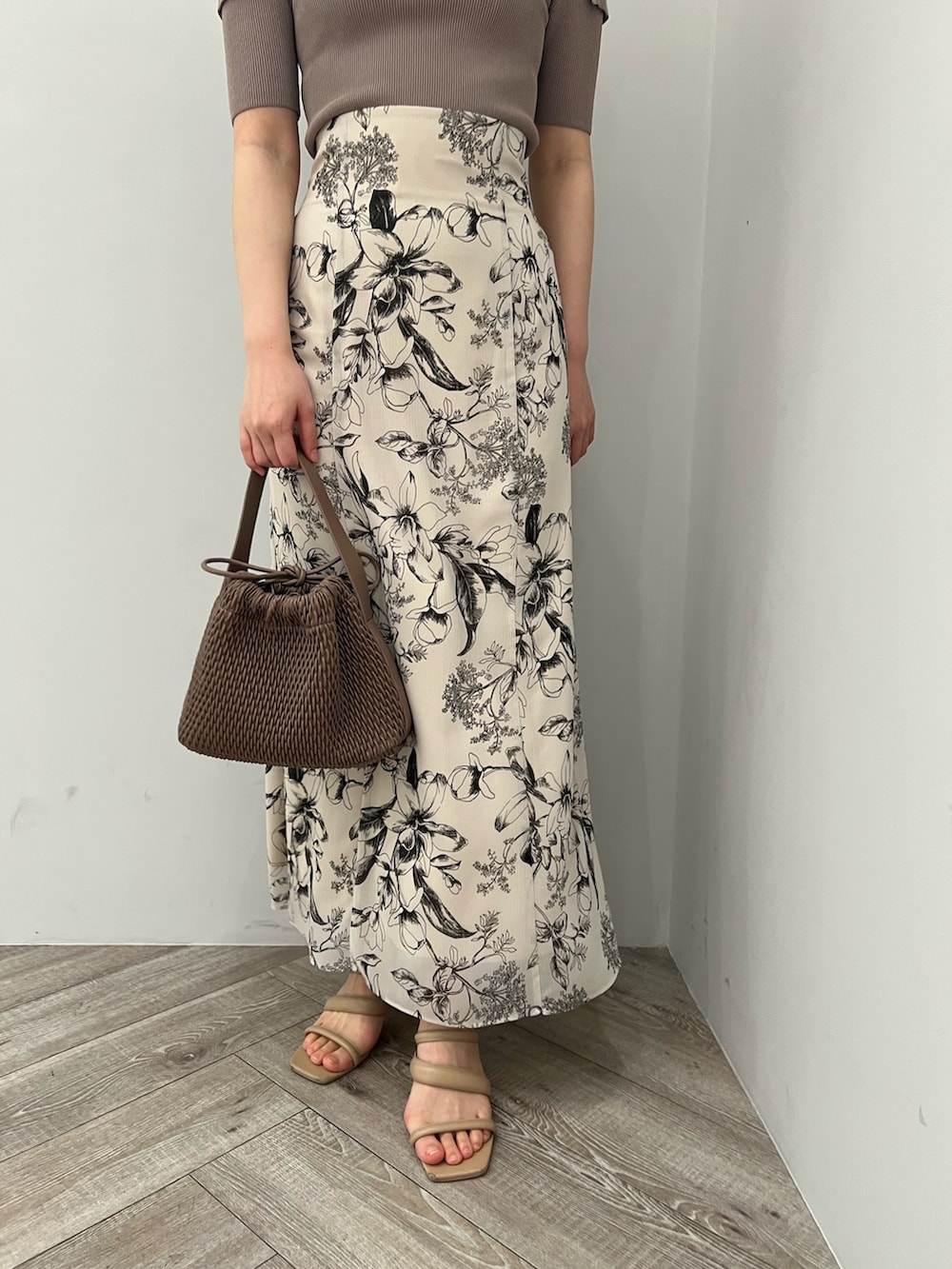 ブラウン系のサンダル、ホワイト系のスカート、ベージュ系のニット/セーターを着用したレディースの春コーディネートの9枚目の写真