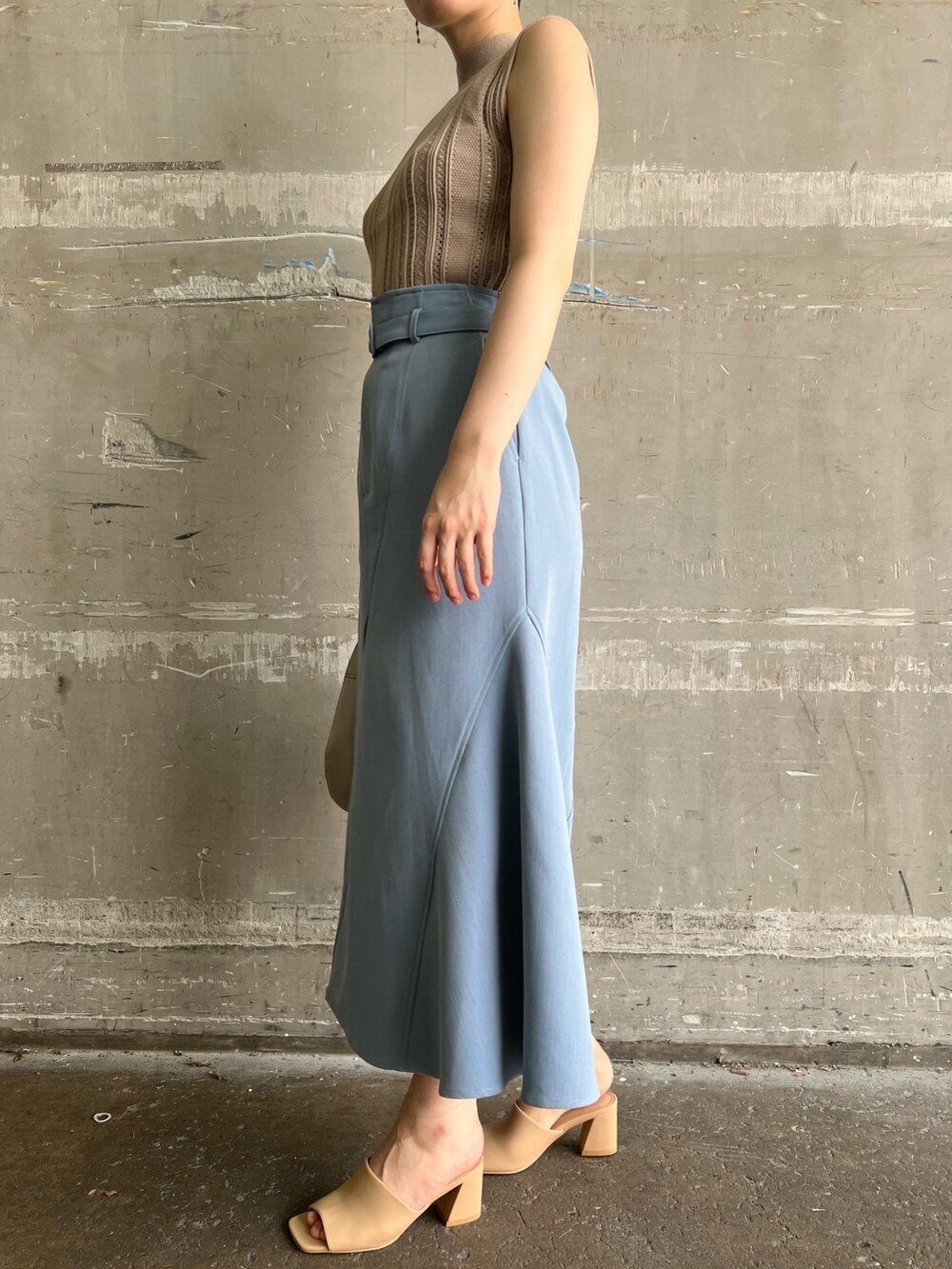 ベージュ系のニット/セーター、ブルー系のスカート、ベージュ系のサンダルを着用したレディースの夏コーディネートの7枚目の写真